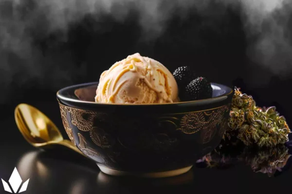 Ice cream in a bowl with berries near a spoon and cannabis nugs.