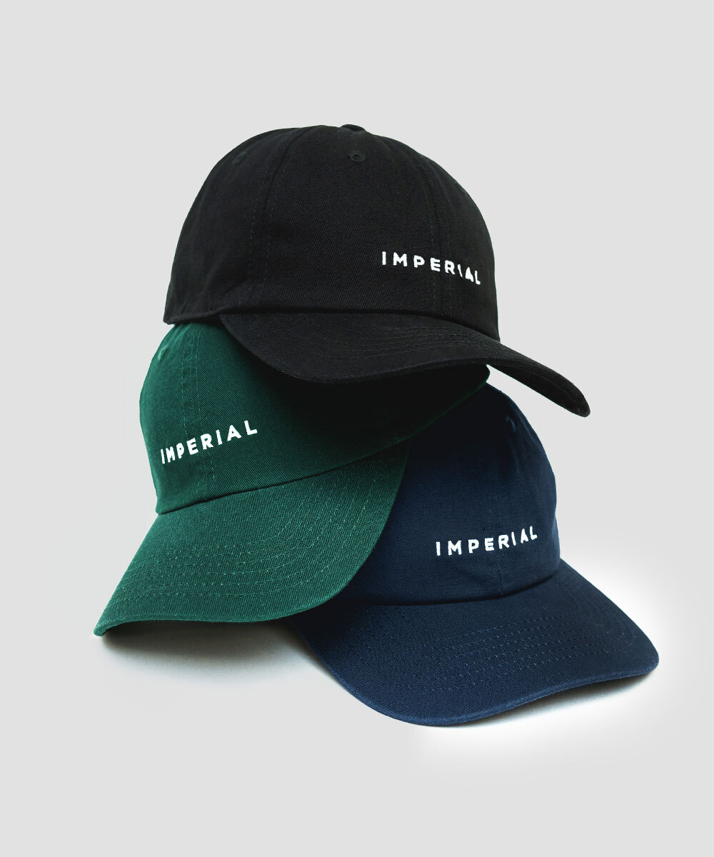 Imperial Merch essentials signature hat in black, green, and blue all stacked together