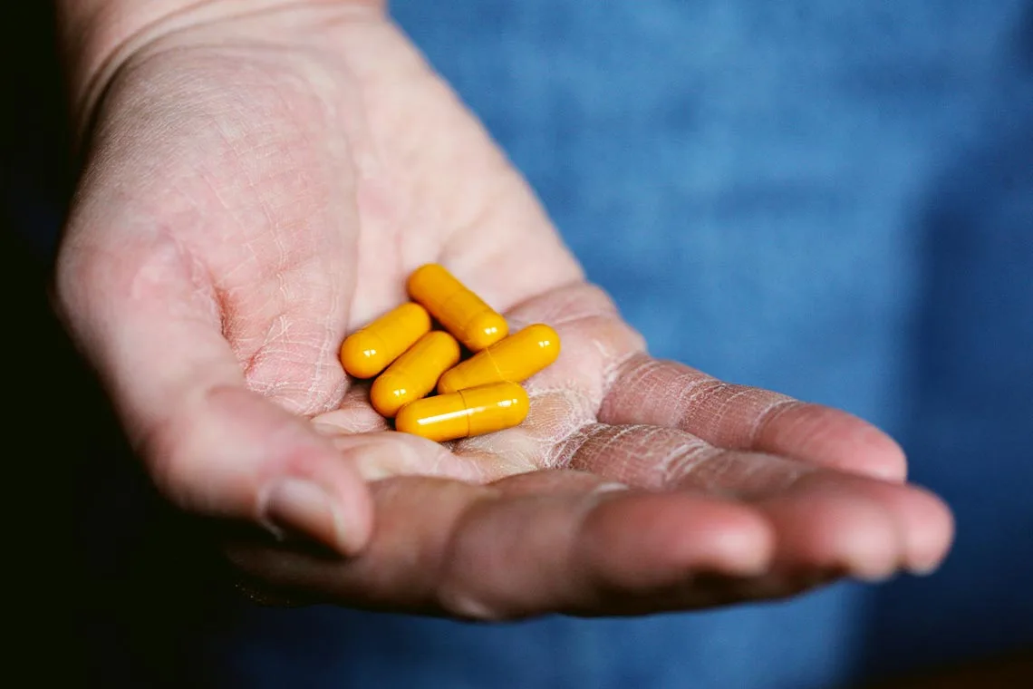 Person Holding Multiple Pills in Their Hand