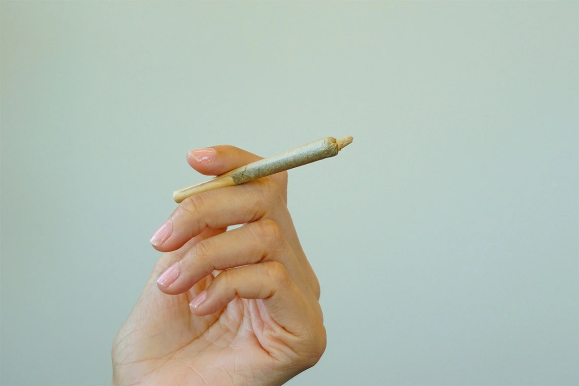 Hand holding a cannabis preroll