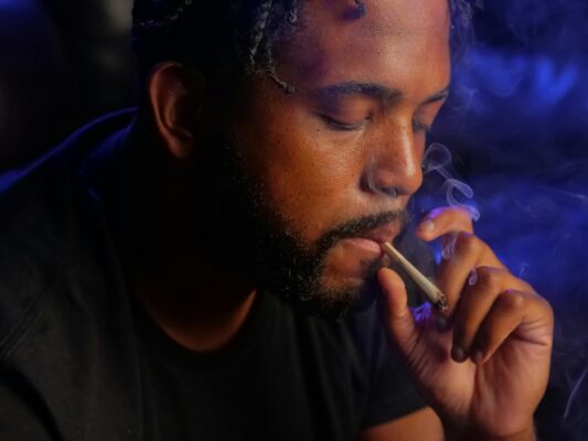 Man in black t-shirt smoking a joint